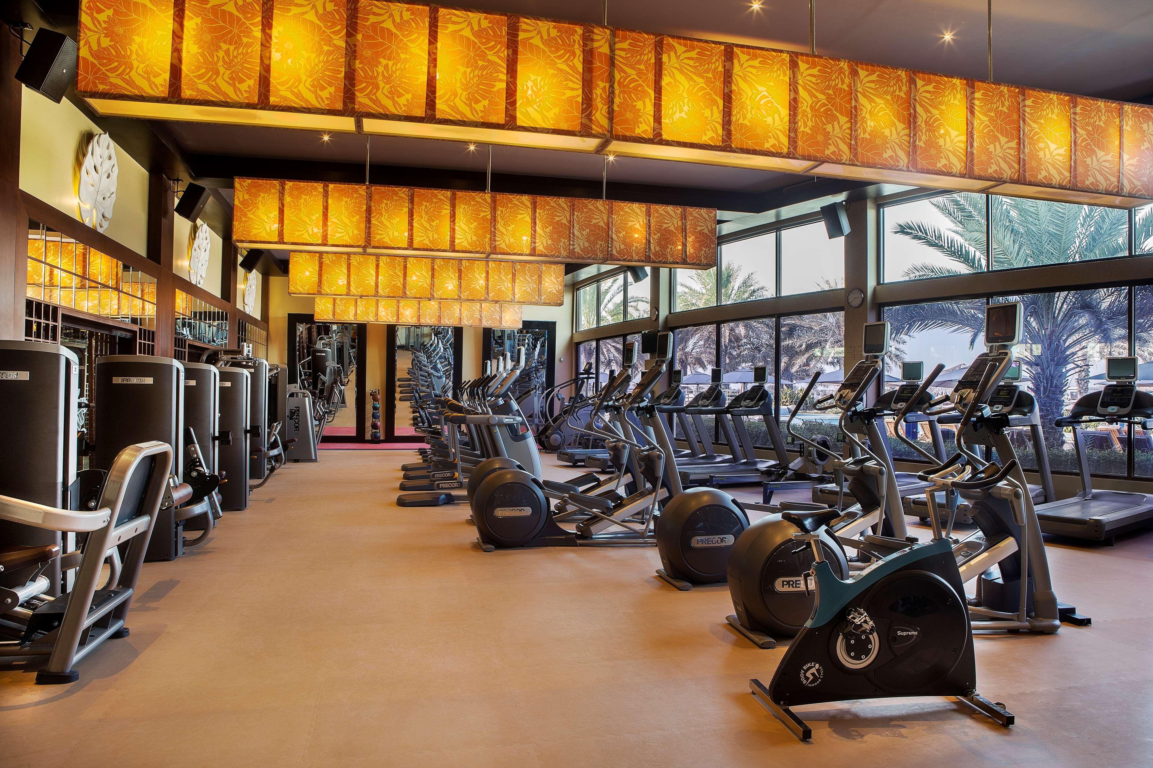 Radisson Blu Hotel & Resort, Abu Dhabi Corniche Exteriör bild The photo shows a modern gym interior with various exercise equipment. The gym features multiple cardio machines, such as treadmills and stationary bikes, arranged neatly. Large windows allow natural light to enter the space, and the walls are decora